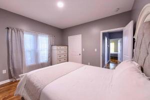 a bedroom with a large white bed and a dresser at The Bungalow in the City - Minutes to Downtown! in Birmingham