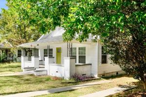 a white house with a porch and a yellow door at The Bungalow in the City - Minutes to Downtown! in Birmingham