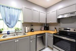 a kitchen with white cabinets and a sink at The Bungalow in the City - Minutes to Downtown! in Birmingham