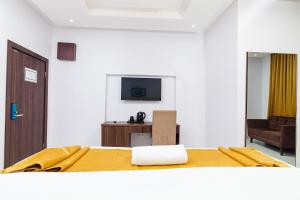 um quarto com uma cama, uma televisão e um sofá em LA FIFTHIN VILLA em Lekki