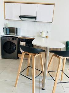 cocina con mesa blanca y 2 sillas en Coastal Retreats, en Ballito