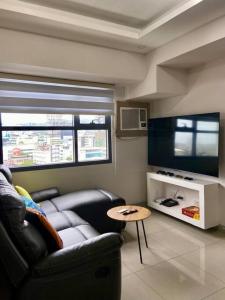 a living room with a couch and a television at Horizon 101 - champito's place in Cebu City
