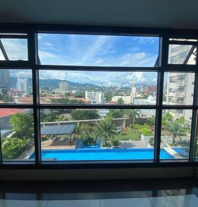 einen Blick auf den Pool von einem Fenster in einem Gebäude in der Unterkunft Horizon 101 - champito's place in Cebu City