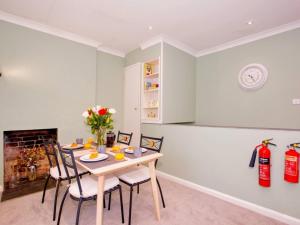 a dining room with a table and chairs and a fireplace at Lovely 2-Bed Apartment Colyton, nr. Jurassic Coast in Colyton +15 photos