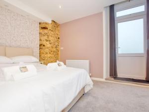 a bedroom with two beds and a large window at Lovely 2-Bed Apartment Colyton, nr. Jurassic Coast in Colyton