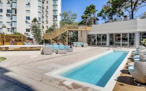 a swimming pool with chairs and a building at Wind Tower, Punta del Este in Punta del Este