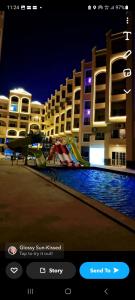 a screenshot of a hotel with a playground in front of a building at Juliana beach resort in el ahead st in El Gouna
