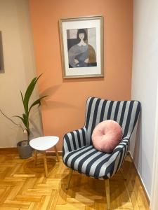 - une chaise bleue et blanche avec un oreiller rose dans l'établissement Sm Athens, à Athènes