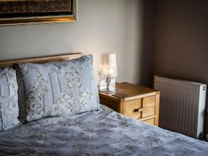 een slaapkamer met een bed en een nachtkastje met een lamp bij Holme Cleve - enjoy the best view of Lyme Regis in Lyme Regis