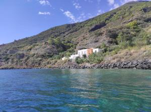una casa su una collina vicino a un corpo d'acqua di Aeolian Sea House a Santa Marina Salina