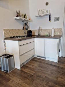 una cocina con armarios blancos y fregadero en Casa Montana, en Tremosine Sul Garda