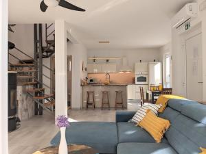 a living room and kitchen with a blue couch at Vila Burin in Tribunj