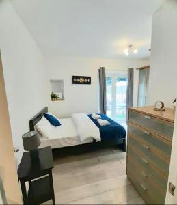 a bedroom with a bed and a dresser at Three bed Ensuites in Edgware in Edgware