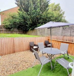 a patio with a table and chairs and an umbrella at Three bed Ensuites in Edgware in Edgware