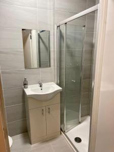 a bathroom with a sink and a shower at Three bed Ensuites in Edgware in Edgware
