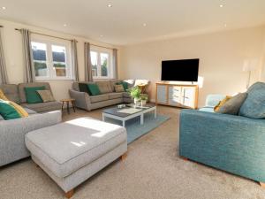 a living room with two couches and a flat screen tv at Devon House in Holsworthy