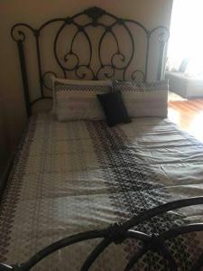 een bed met een metalen hoofdeinde in een slaapkamer bij Lovely one bedroom with free parking in Schenectady
