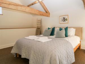 a bedroom with a large bed with blue pillows at Barn Cottage in Leominster