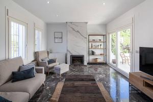 ein Wohnzimmer mit Couch und Kamin in der Unterkunft Espectacular villa close to Sevilla - Sevillarooms in Valencina de la Concepción