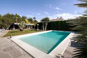 ein großes Schwimmbad in einem Hof mit Bäumen in der Unterkunft Espectacular villa close to Sevilla - Sevillarooms in Valencina de la Concepción