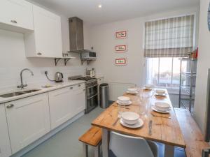 a kitchen with a wooden table with plates on it at Osprey in Southwold +12 photos