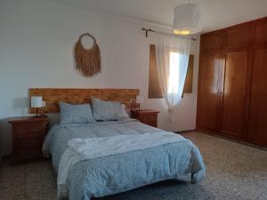 1 dormitorio con 1 cama con manta azul y ventana en Casa de Familia Felipe y Martin, en Tías