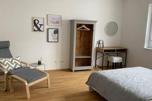 een slaapkamer met een bed, een stoel en een bureau bij nummer22 in Eschenbach in der Oberpfalz