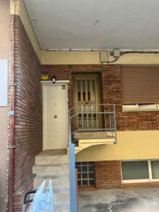 un edificio de ladrillo con puerta y balcón en Precioso apartamento en Premià de Dalt, en Premià de Dalt