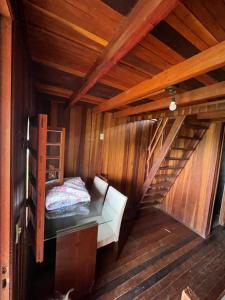 Cette chambre comprend un lit dans une cabane en bois. dans l'établissement Fazendinha Tonero, à Atibaia