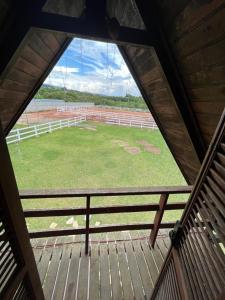 - une vue depuis l'intérieur d'une grange avec un grand champ dans l'établissement Fazendinha Tonero, à Atibaia