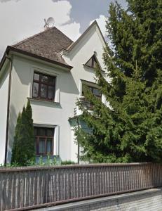 una casa blanca con una valla y un árbol en Rezidence Bratrská, en Ostrava