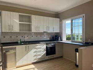 a kitchen with white cabinets and a window at Casa Romántica in El Paso
