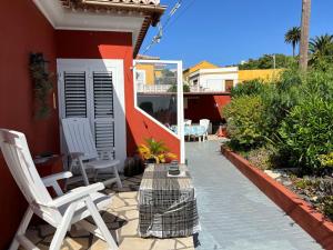 un patio con 2 sedie bianche e un tavolo di Casa Romántica a El Paso