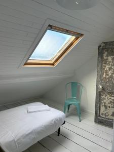 a bedroom with a bed and a blue chair at Grande maison de pêcheur - centre de Trouville in Trouville-sur-Mer