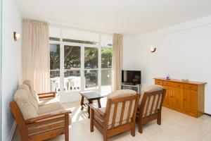 uma sala de estar com duas cadeiras e uma televisão em Apartamentos Blanes-Condal Costa Brava em Blanes