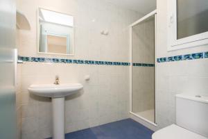 uma casa de banho branca com um lavatório e um chuveiro em Apartamentos Blanes-Condal Costa Brava em Blanes