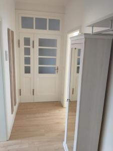 a hallway with a white door and a wooden floor at Ferienwohnung Wiebe in Minden
