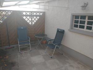 un patio con 2 sillas, una mesa y una ventana en Ferienwohnung Wiebe, en Minden