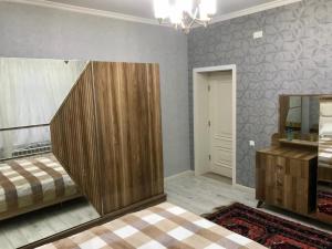 - une chambre avec un lit, une commode et un miroir dans l'établissement Вилла в г.Кусары, à Qusar