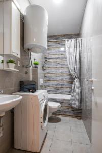 a bathroom with a toilet and a sink and a washing machine at !PROMO! Giallo Modern Studio-Free Private Parking-Fast WI-FI in Novi Sad