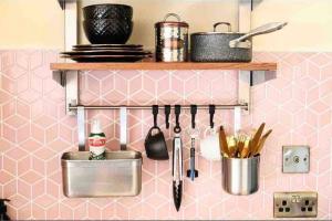 a pink kitchen with utensils on a wall at Dalriada Den - Luxury GeoDome in Portpatrick