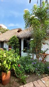a thatch roofed house with plants in front of it at CASA AUM in Brisas de Zicatela