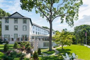 un gran edificio blanco con un árbol en el patio en The Pridwin Hotel en Shelter Island