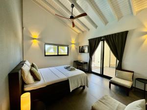sypialnia z łóżkiem i wentylatorem sufitowym w obiekcie Salt Apartments Bonaire w mieście Kralendijk