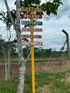 una señal frente a una valla junto a un árbol en Espaço Leão Eventos, en Rio Branco
