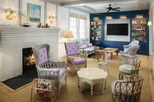 a living room with a fireplace and chairs and a tv at The Pridwin Hotel in Shelter Island