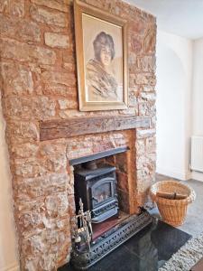 a brick fireplace with a portrait of a woman at The kings in Denbigh