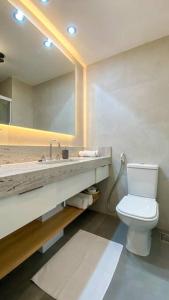 uma casa de banho com um lavatório, um WC e um espelho. em Atlântico Collection no Rio de Janeiro