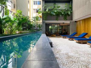 a swimming pool with blue chairs and a building at Atlântico Collection in Rio de Janeiro
