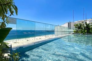 a swimming pool with a view of the beach at Atlântico Collection in Rio de Janeiro